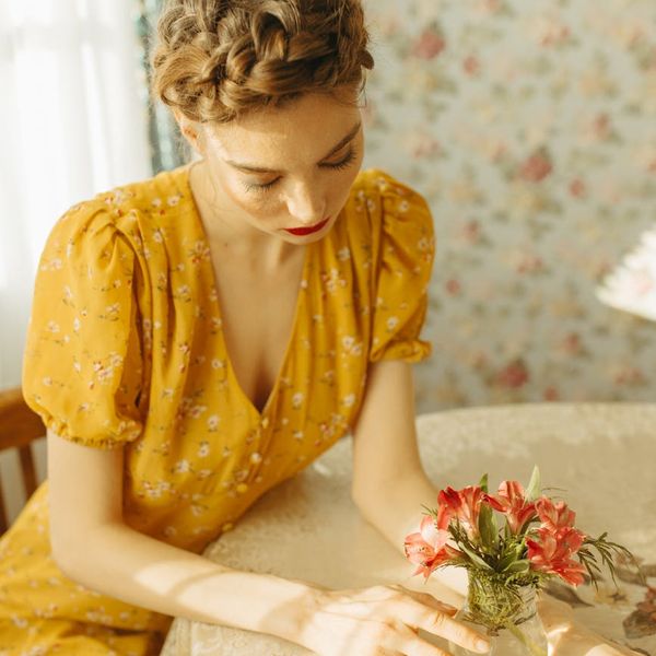 Woman meditating peacefully in a bright, sunlit room.